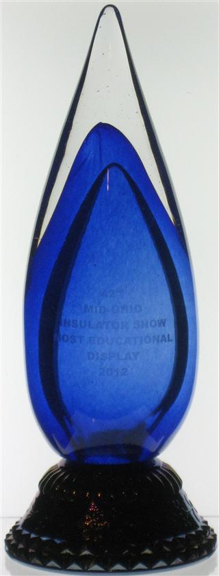 Wilkerson made trophy.  Clear/cobalt top, with cobalt pressed glass base that is carnivalized.  

42nd
MID-OHIO
INSULATOR SHOW
MOST EDUCATIONAL
DISPLAY
2012

signed at the juncture of the base and top
Wilkerson  2012