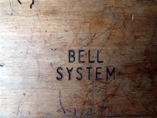Small step stool.  Wood, likely oak.  Sqaure, with "BELL SYSTEM" burned in.  