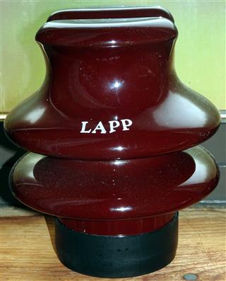 Linepost style cable top.  Marked

LAPP

in silver.  Plastic seal around the bottom